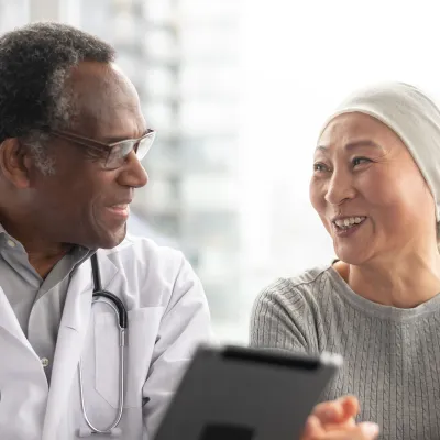 A doctor speaks with a patient undergoing cancer treatment. 