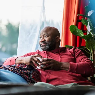 man drinking coffee by window