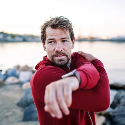 man stretching in red shirt